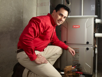 HVAC technician kneeling next to an indoor unit | Bennett Heating & Air