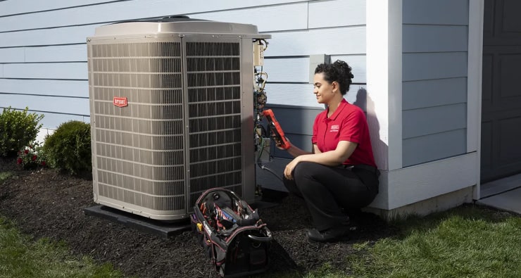 HVAC service technician checking outdoor unit | Bennett Heating & Air