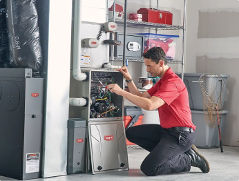 AC repair technician working on an indoor unit in a garage | Bennett Heating & Air