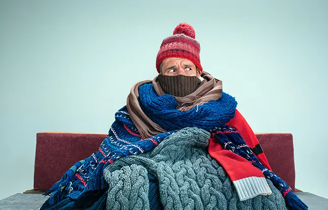 Cold Man sitting wrapped in scarves | Heating Repairs | Bennett Heating and Air LLC