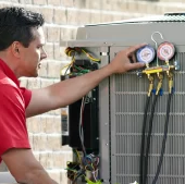 A HVAC Technician checking and servicing a outdoor AC Unit | Bennett Heating and Air LLC