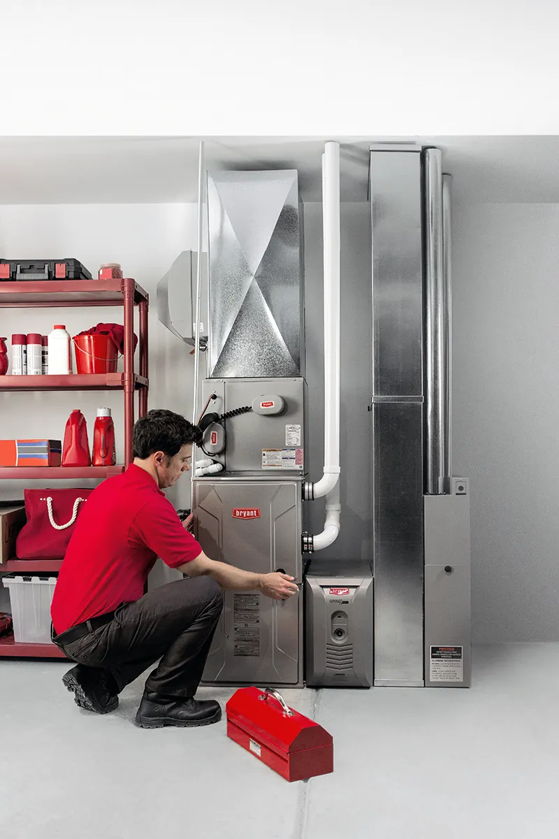 HVAC Technician Installing a gas furnace system in a home's basement | Bennett Heating and Air LLC
