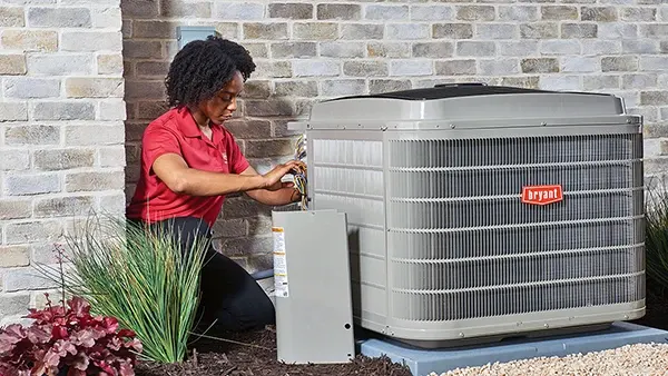 A female HVAC Technician fixing a outdoor AC Unit | Bennett Heating and Air LLC