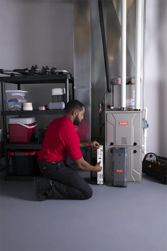HVAC Technician installing a new filter in homeowners basement | Bennett Heating and Air