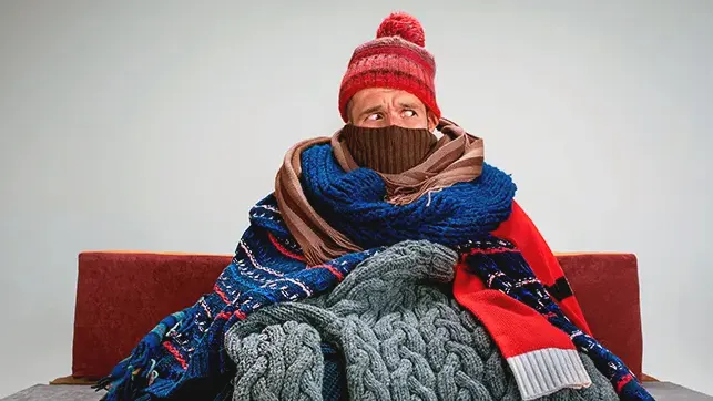 Cold Man sitting wrapped in scarves | Heating Repairs | Bennett Heating and Air LLC