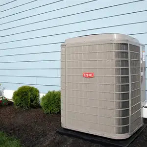 Outdoor air conditioning unit installed outside a light blue home AC Install Bennett Heating and Air